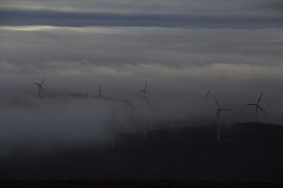 Windmills on field against sky