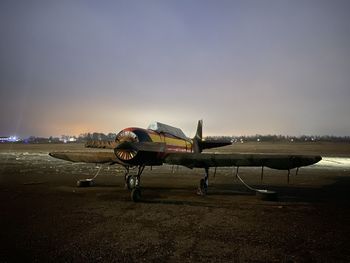 Airplane on airport runway against sky