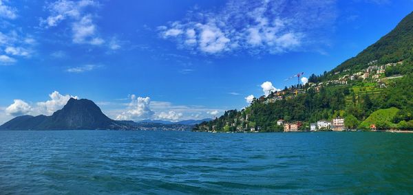 Panoramic view of sea and mountains against blue sky