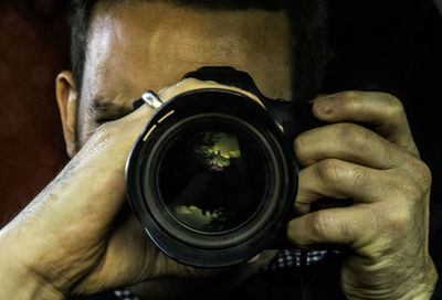 Close-up of man photographing camera