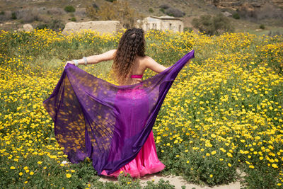 Woman performing belly oriental dancing wearing coloured costume. dancing outdoors