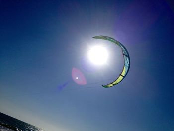 Low angle view of sun shining through clouds