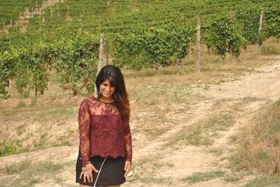 Smiling young woman standing in vineyard