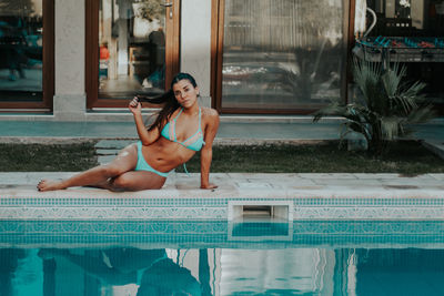 Woman sitting in swimming pool