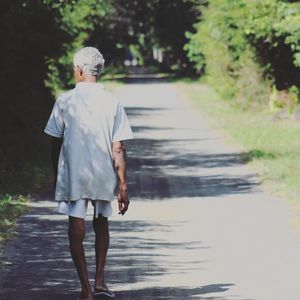 Rear view of man walking on footpath