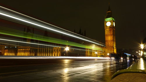 Light trails on street amidst buildings at night