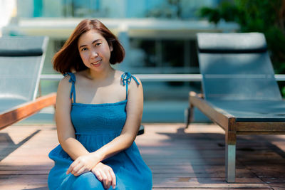 Portrait of young woman sitting on chair