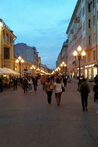 People walking on city street at night