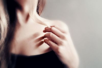 Close-up portrait of woman with hand on hair