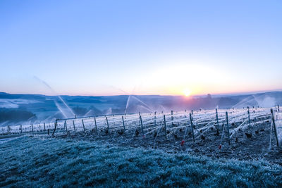 Scenic view of snowy field against sky during sunset