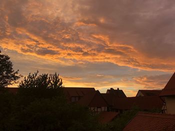 Houses and buildings against sky during sunset