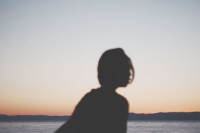 Silhouette of man at beach against sky