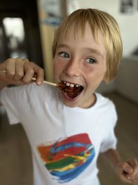 Portrait of cute baby boy eating food at home