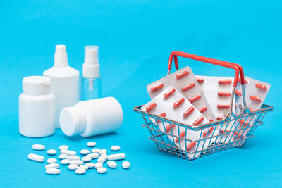 High angle view of pills in container against blue background
