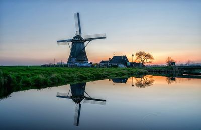 Scenic view of windmill against sky during sunset
