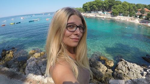 Portrait of smiling young woman against sea