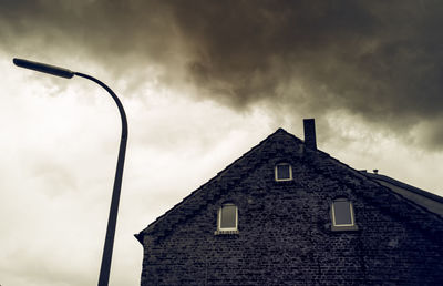 Low angle view of building against cloudy sky