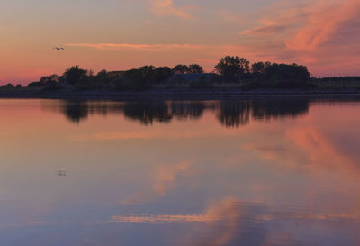 Scenic view of lake against orange sky
