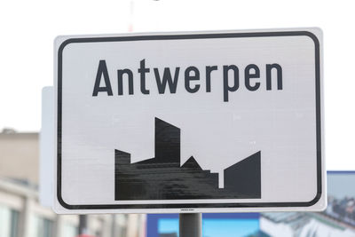 Close-up of road sign against sky