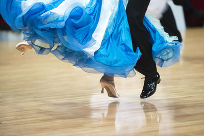 Low section of couple dancing on hardwood floor