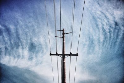 Low angle view of mast against cloudy sky