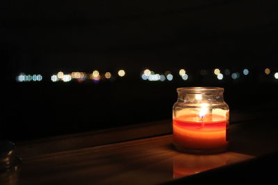 Close-up of illuminated tea light candle on table