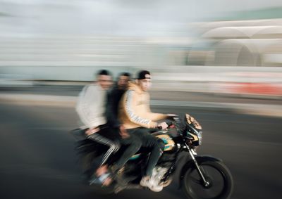 Man riding bicycle on road in city