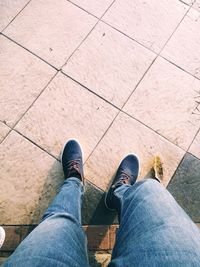 Low section of man standing on tiled floor