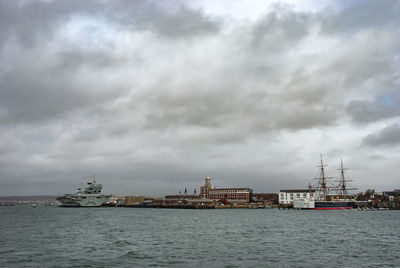 Sea by buildings against sky