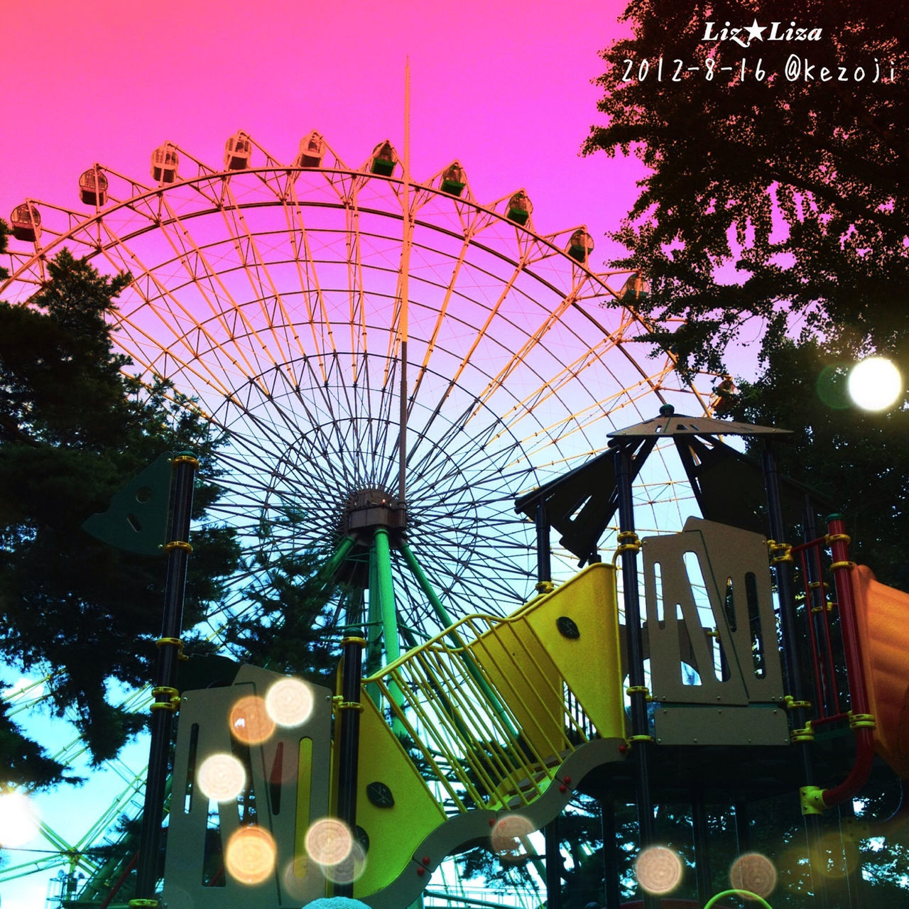 low angle view, illuminated, built structure, lighting equipment, architecture, sky, amusement park, arts culture and entertainment, ferris wheel, amusement park ride, decoration, tree, building exterior, night, multi colored, ceiling, hanging, clear sky, no people, outdoors