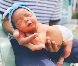 Midsection of man holding newborn baby