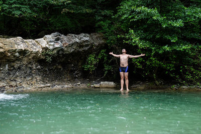 Full length of shirtless man standing in water