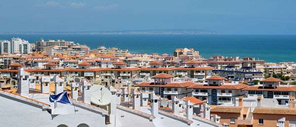 High angle view of townscape by sea against sky