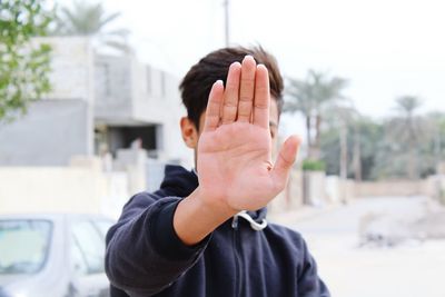 Man showing stop gesture while standing outdoors