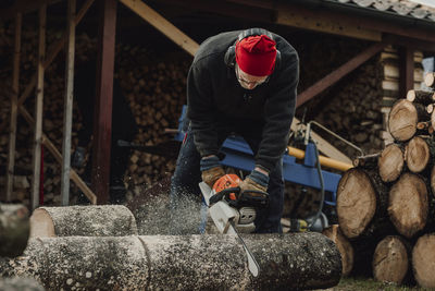 Senior man using chainsaw