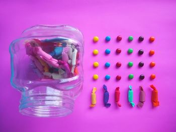 High angle view of colorful candies against pink background