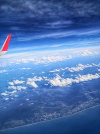 Aerial view of aircraft wing against blue sky