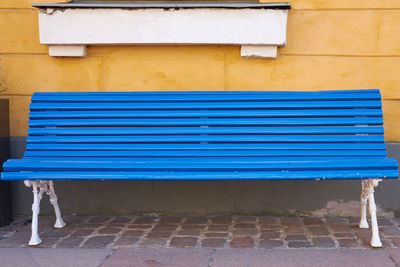 Empty bench against wall