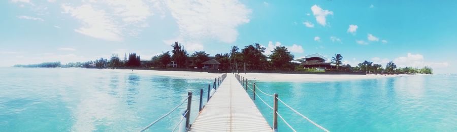 Panoramic view of swimming pool by sea against sky