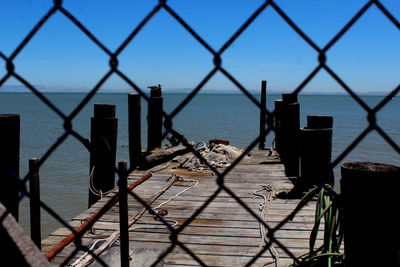 Close-up of chainlink fence against sea