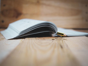 Close-up of pencil in open book on table