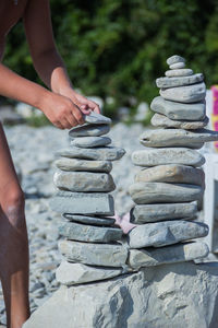 Cropped image of man stacking stones