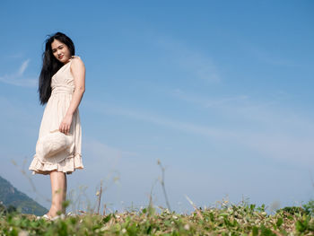 Full length of woman standing on field against sky