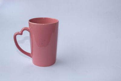 Close-up of empty coffee cup on table against white background