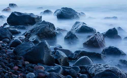 Scenic view of rocks in sea against sky