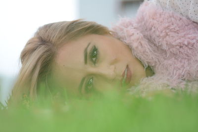 Portrait of beautiful woman lying on field