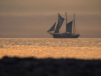 Boat on sea against clear sky during sunset