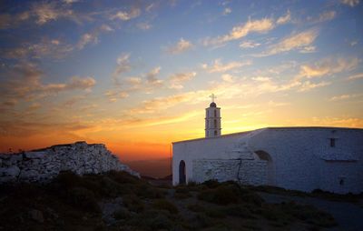 Whitewashed church against sky during sunset