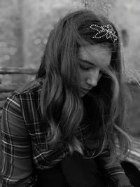 Close-up of thoughtful woman sitting against wall