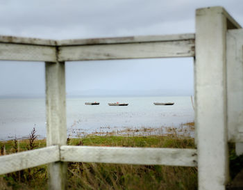 Scenic view of sea against sky seen through fence